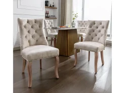 Conjunto de 4 sillas de terciopelo beige claro con patas de madera curvadas y botones decorativos.