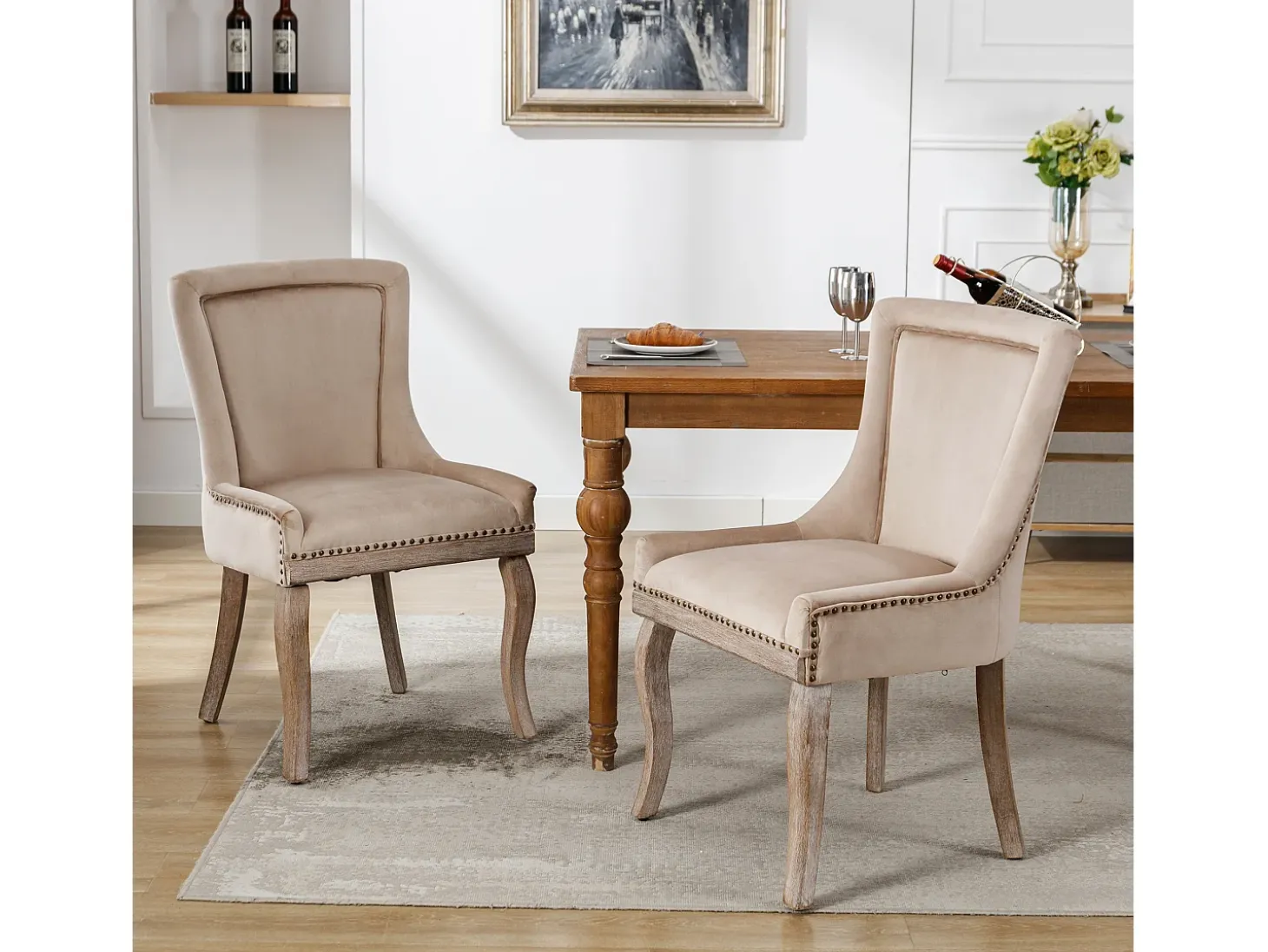 Conjunto de 2 sillas de terciopelo beige con patas de madera curvadas y remaches dorados.
