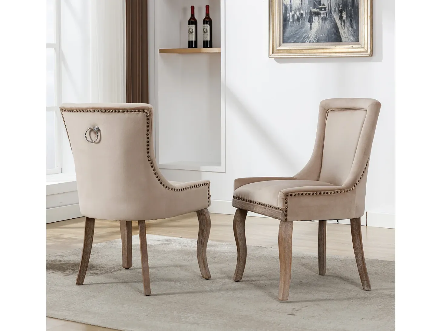 Conjunto de 2 sillas de terciopelo beige con patas de madera curvadas y remaches dorados.