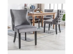Juego de 4 sillas de terciopelo gris con patas de madera gris, botones decorativos y remaches plateados.