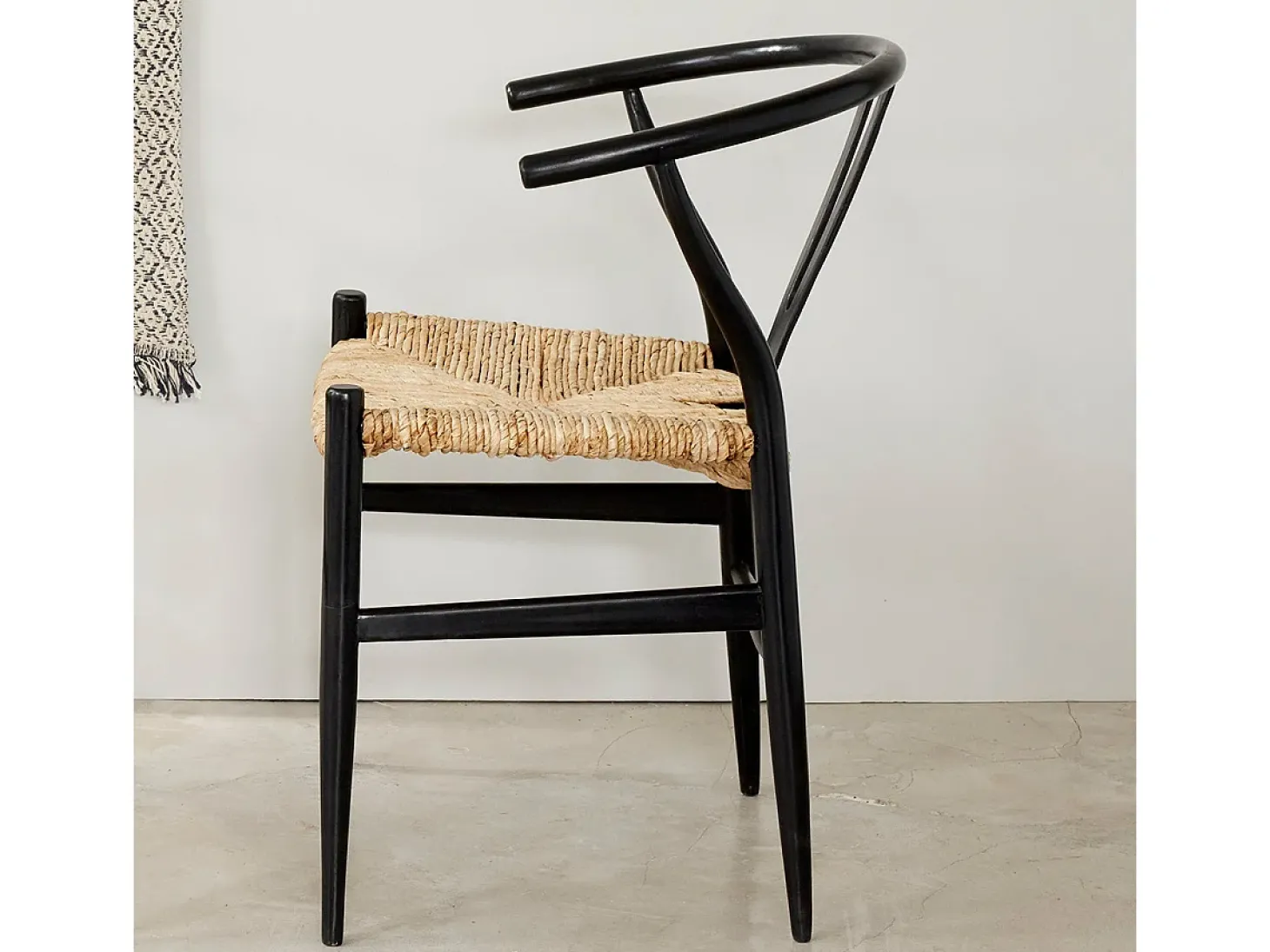 Silla negra de madera de mindy con asiento tejido