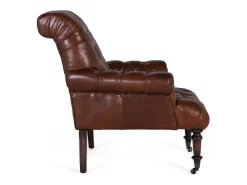 Sillón tapizado en cuero con reposabrazos acabado en capitoné